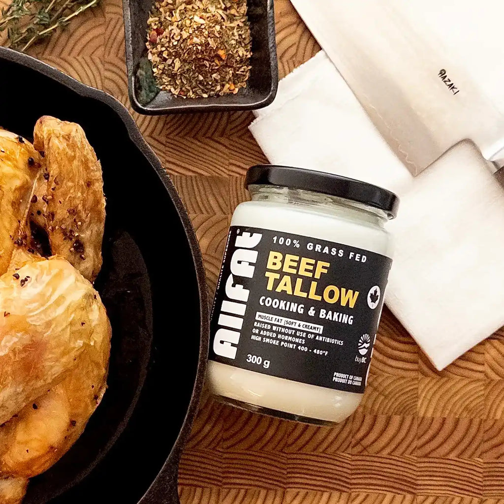 Jar of beef tallow with roasted chicken and spices on a wooden surface