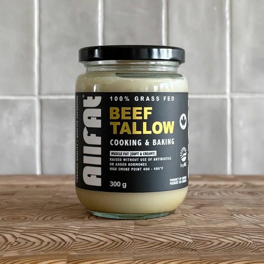 Jar of beef tallow on a wooden surface with a tiled wall background