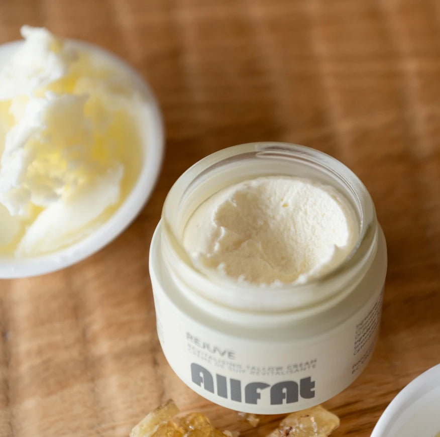 Jar of tallow cream on a wooden surface, featuring the brand 'AIIFAT'.