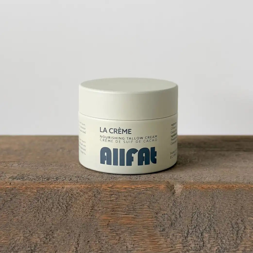 Jar of La Crème Nourishing Tallow Cream by Allfat on a wooden surface with a white background