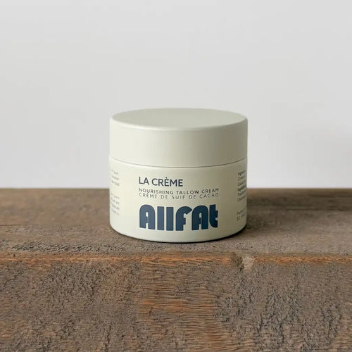 Jar of La Crème Nourishing Tallow Cream by Allfat on a wooden surface with a white background