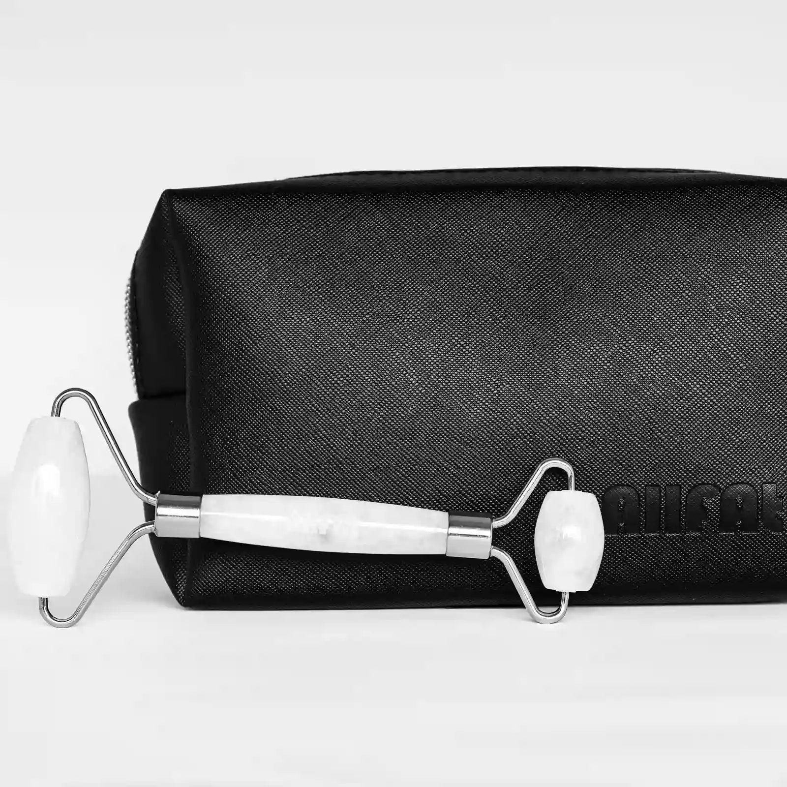 Skincare roller with black pouch on a light gray background