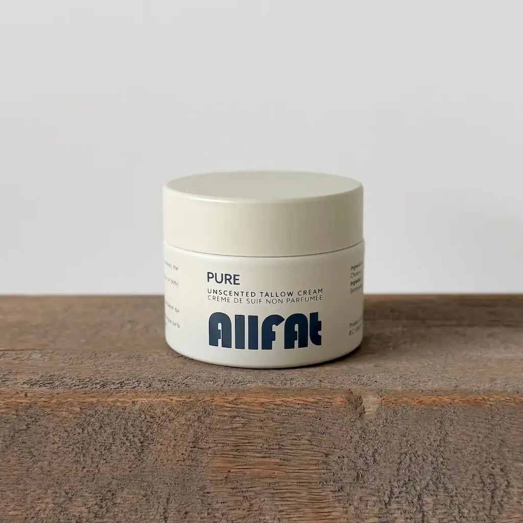 Jar of 'PURE' tallow cream by Allfat on a wooden surface with a gray background