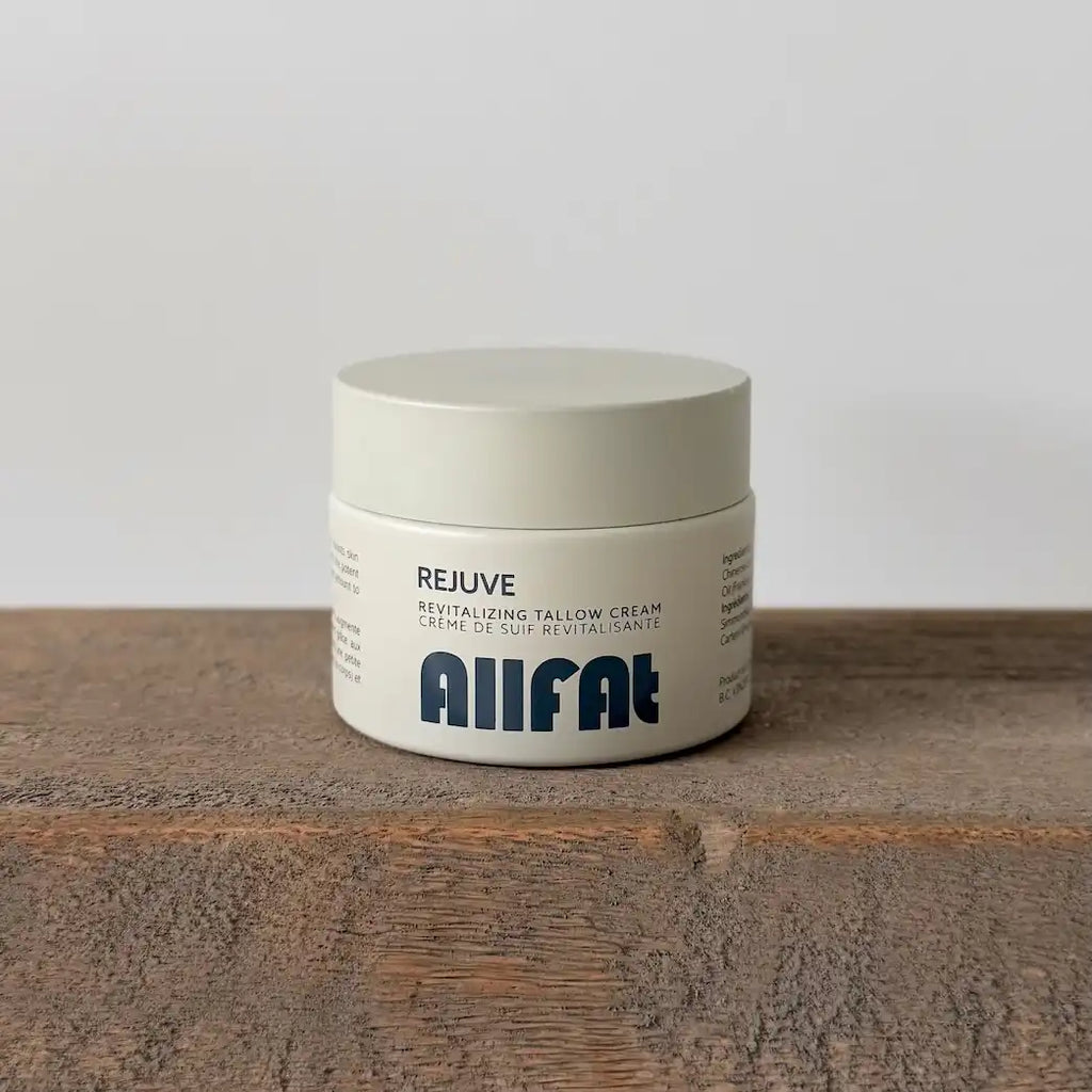 Jar of allfat tallow cream on a wooden surface with a white background