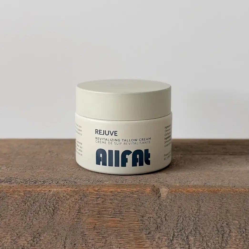 Jar of allfat tallow cream on a wooden surface with a white background