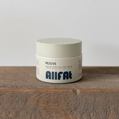Jar of allfat tallow cream on a wooden surface with a white background